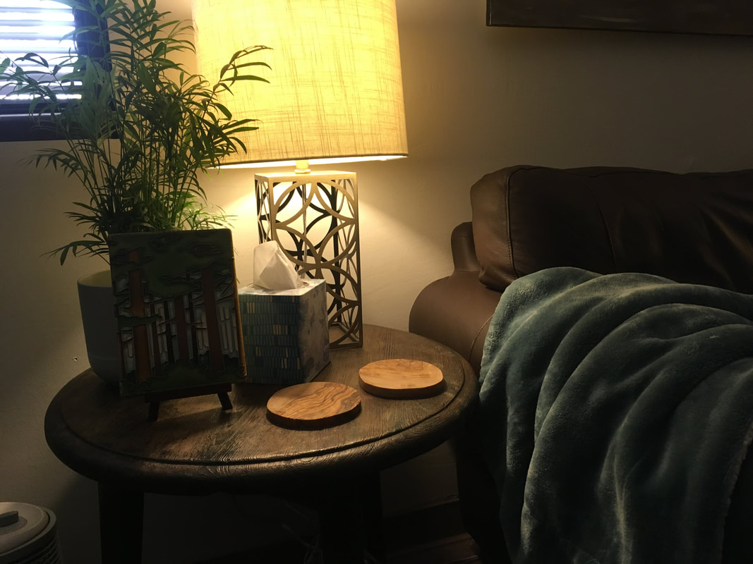 Photo of lamp and plant on side table next to couch.